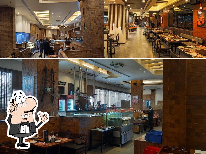 Take a seat at one of the tables at Barbeque Nation - Pune - Deccan