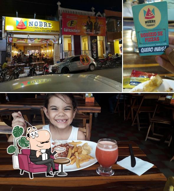 Sente em uma das mesas no Nobre - Restaurante e Pizzaria