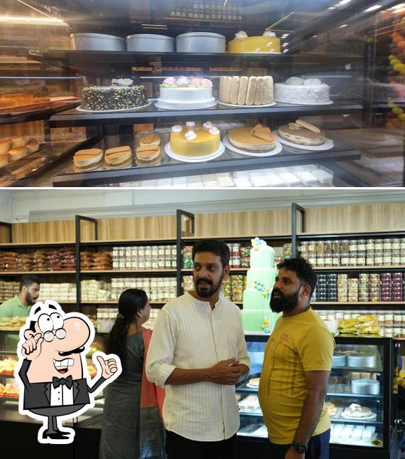 Take a seat at one of the tables at Calicut Bakers And Restaurant Kacheri pady