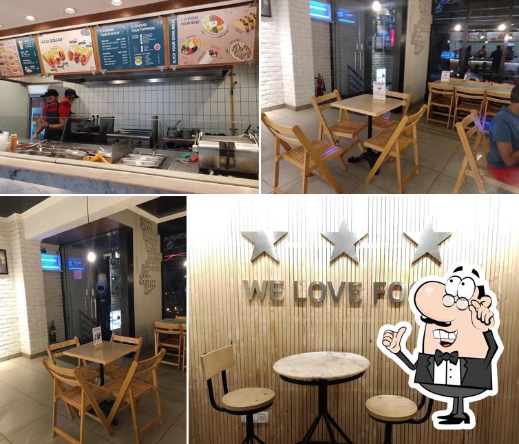 Take a seat at one of the tables at California Burrito Mexican Kitchen @ Sarjapur