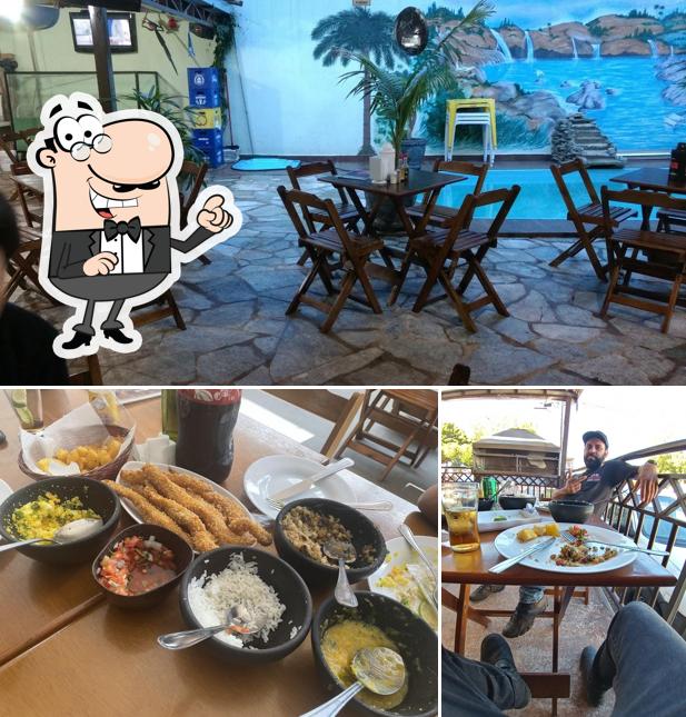 Sente em uma das mesas no Casa da Tilápia