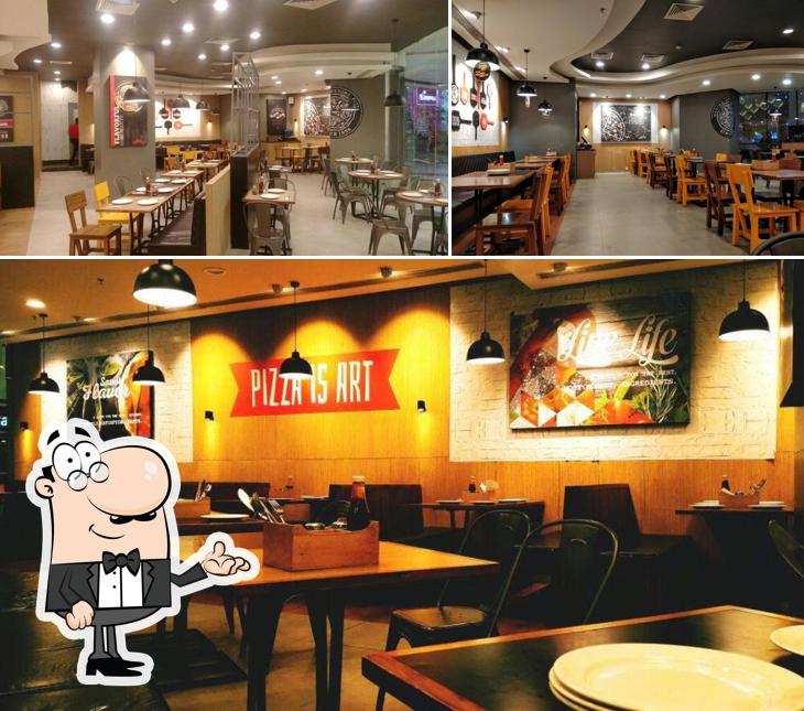 Take a seat at one of the tables at Pizza Hut MP Nagar, Bhopal