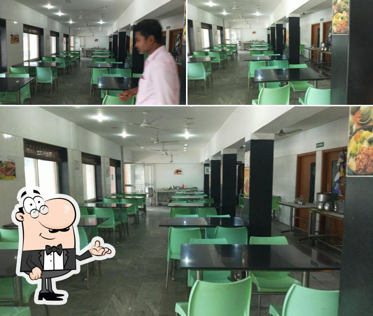 Take a seat at one of the tables at CM VELU HOTEL