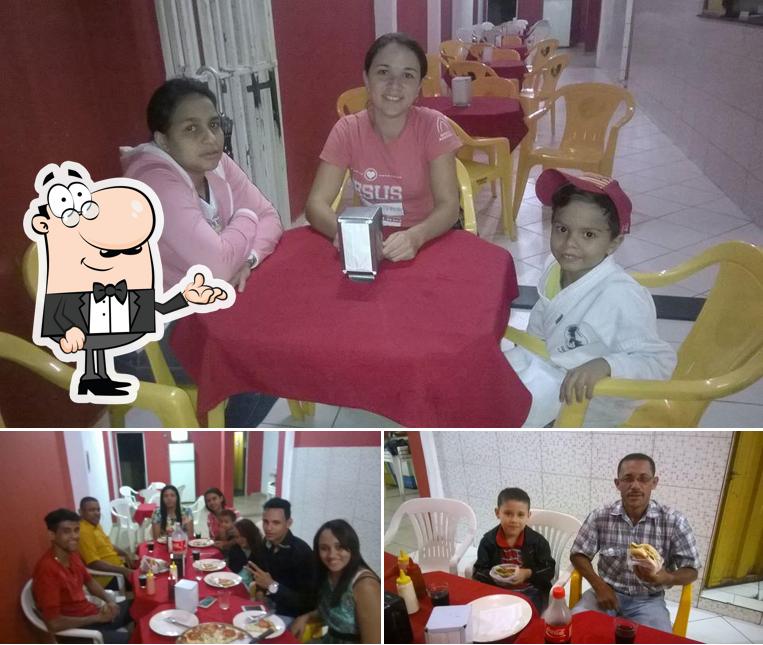Sente em uma das mesas no Dim Lanches & Pizzaria
