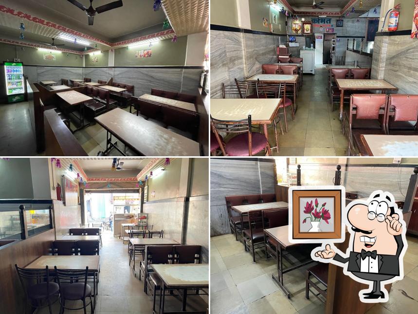 Take a seat at one of the tables at Kamat Hotel