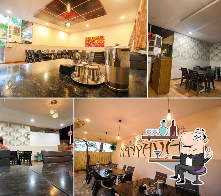 Take a seat at one of the tables at Hotel Manyavar Pure Veg Family Garden & Restaurant