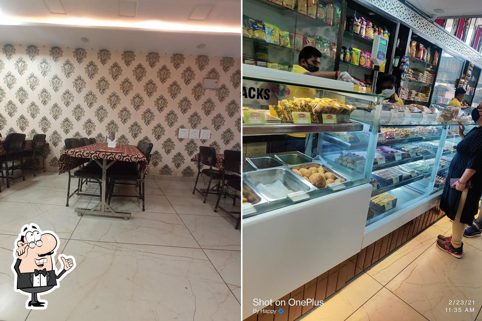 Take a seat at one of the tables at Kanhaji Sweets and Restaurant
