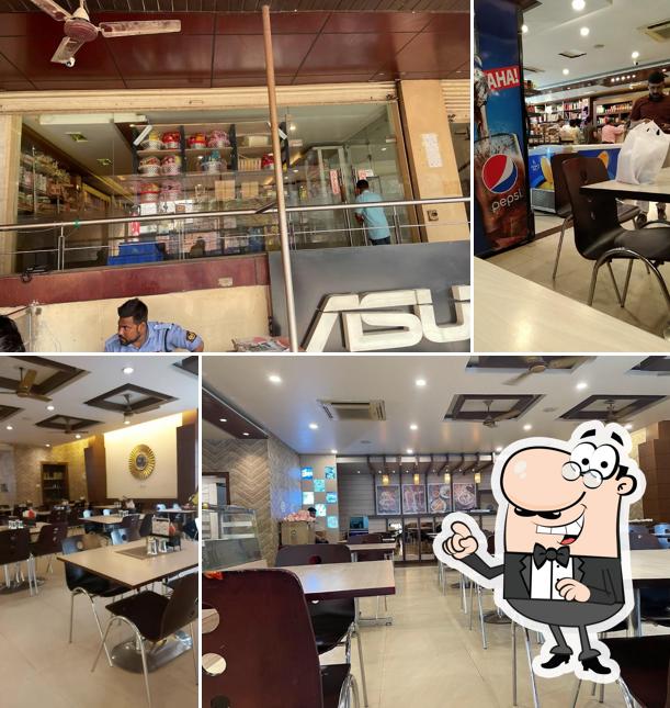 Take a seat at one of the tables at Navrang Sweets & Fast Food