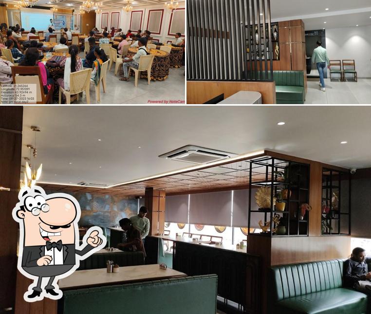 Take a seat at one of the tables at Harikrushna Restaurant & Banquet