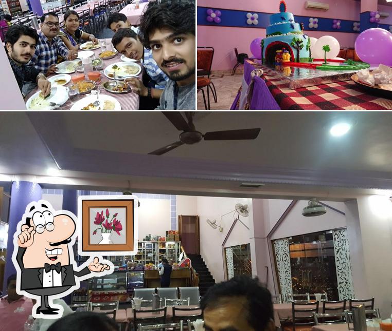 Take a seat at one of the tables at Tripti Restaurant & Sweets Home