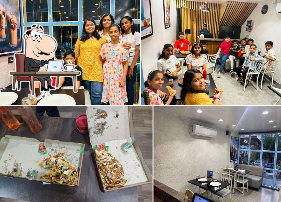 Take a seat at one of the tables at The Pizza Box & Cafe Sinhagad road Pure Veg