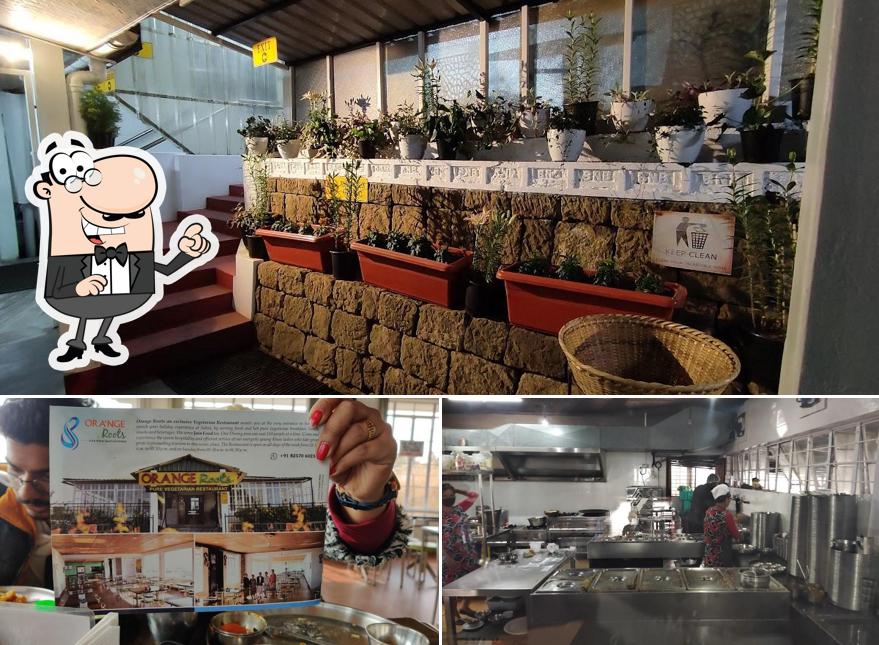 Take a seat at one of the tables at Orange Roots, Pure Veg Restaurant