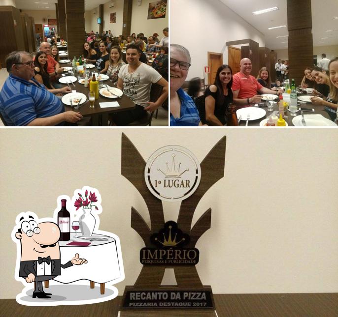 Confira a imagem mostrando mesa de jantar e exterior a Recanto Da Pizza