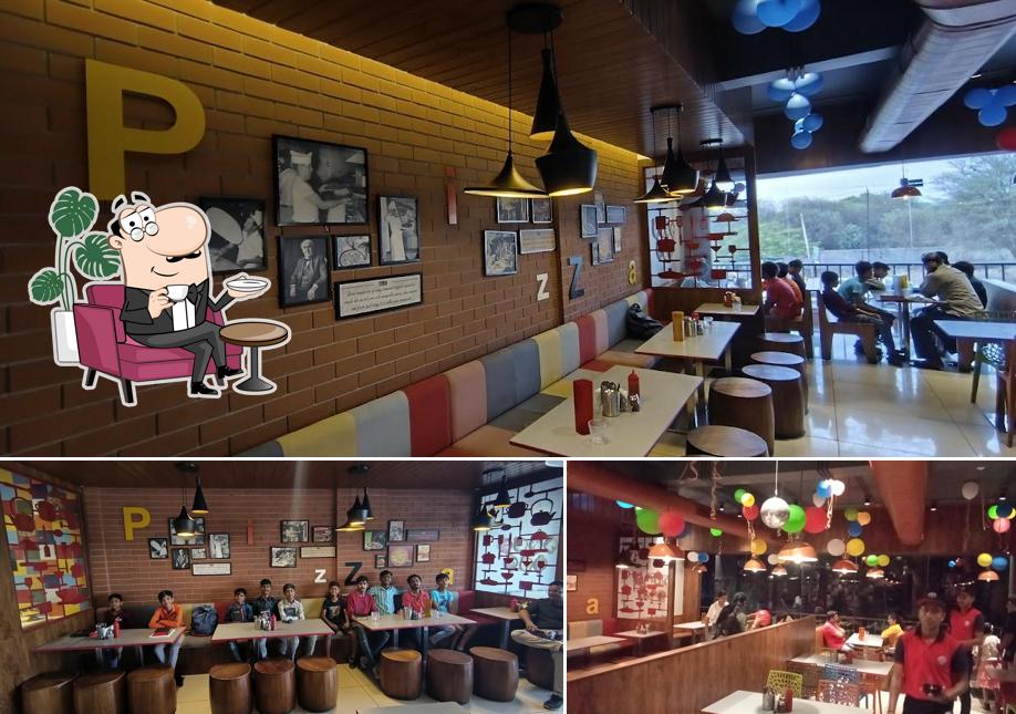 Take a seat at one of the tables at Pizza Zone - Nadiad