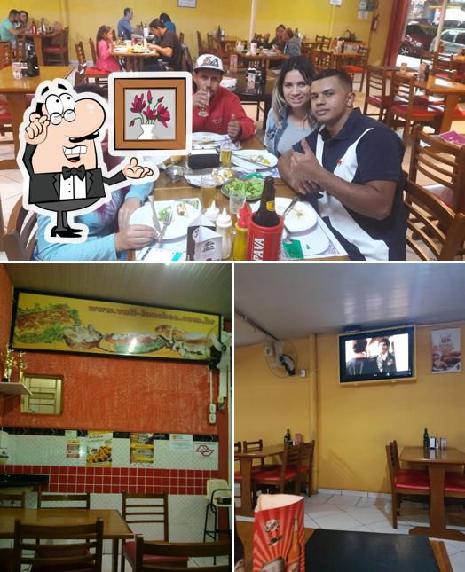 Sente em uma das mesas no Vall Lanches