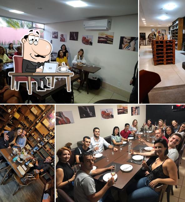 Sente em uma das mesas no Vinoteca Escola de Vinhos e Adega