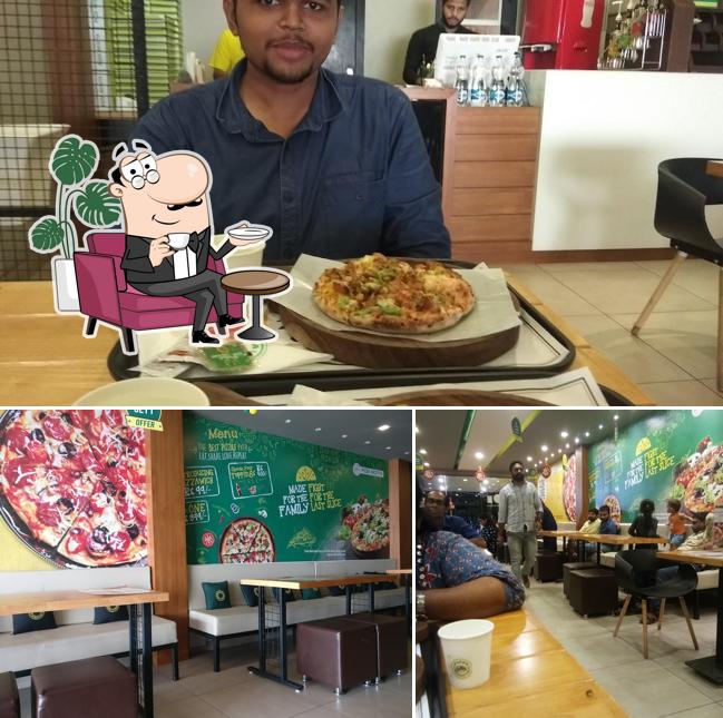 Take a seat at one of the tables at PIZZA RICOTTA Beach - Best Pizza in Calicut