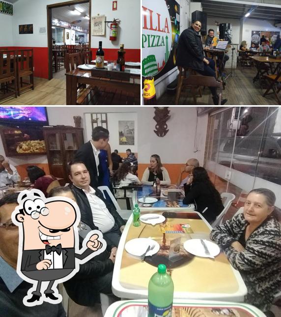 Sente em uma das mesas no Villa Pizza Delivery