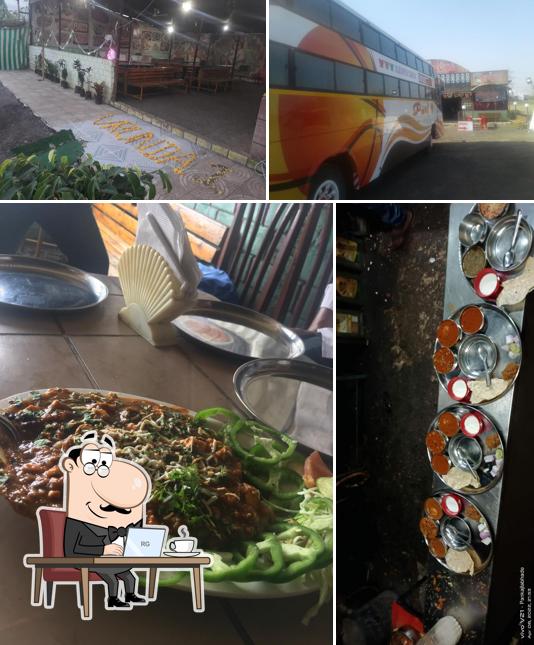 Take a seat at one of the tables at HOTEL VRUNDAVAN FAMILY GARDEN & RESTAURANTS