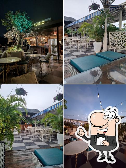 Take a seat at one of the tables at Auric Restaurant & Rooftop Cafe