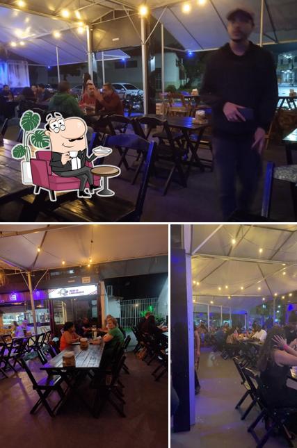 Sente em uma das mesas no Tobas Bar & Espeteria