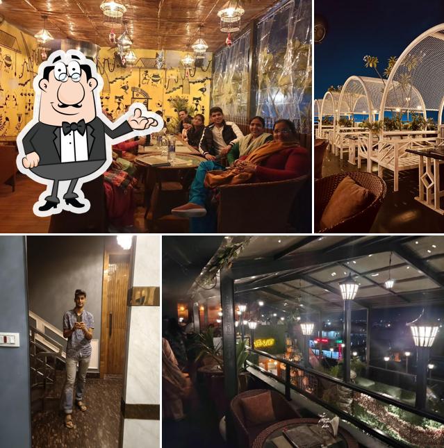 Take a seat at one of the tables at QAENAT MULTICUISINE ROOFTOP RESTAURANT