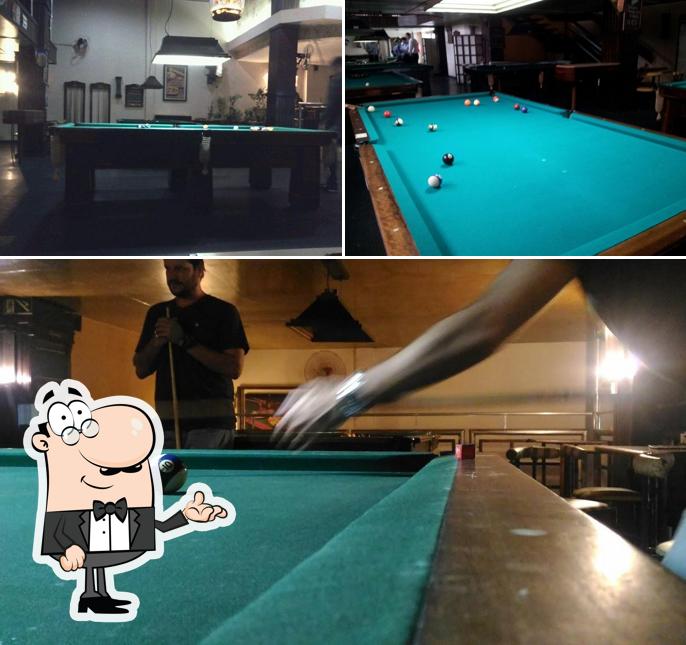 Sente em uma das mesas no Queen's Snooker Burger Bar