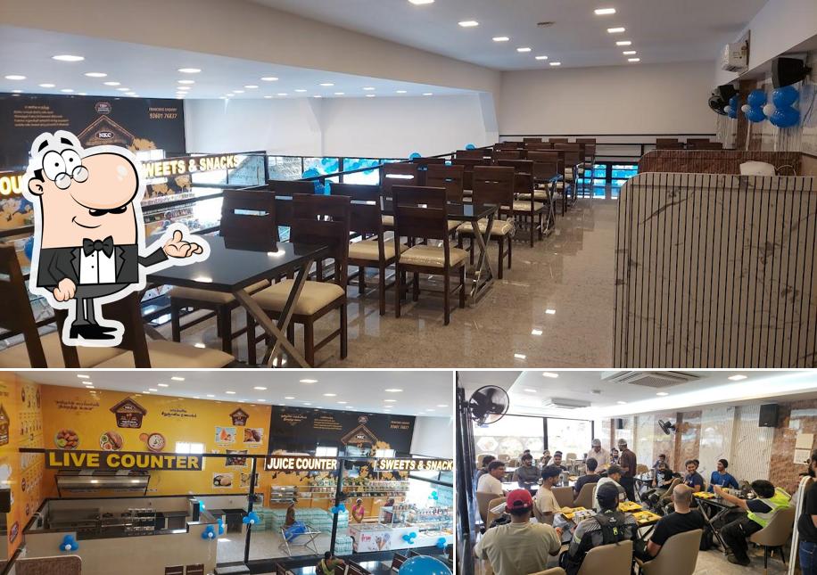 Take a seat at one of the tables at DD RESTAURANT A/C VEG RESTAURANT