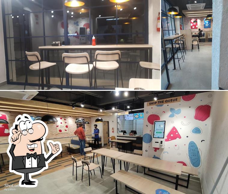 Take a seat at one of the tables at Domino's Pizza Angamaly, Kerala