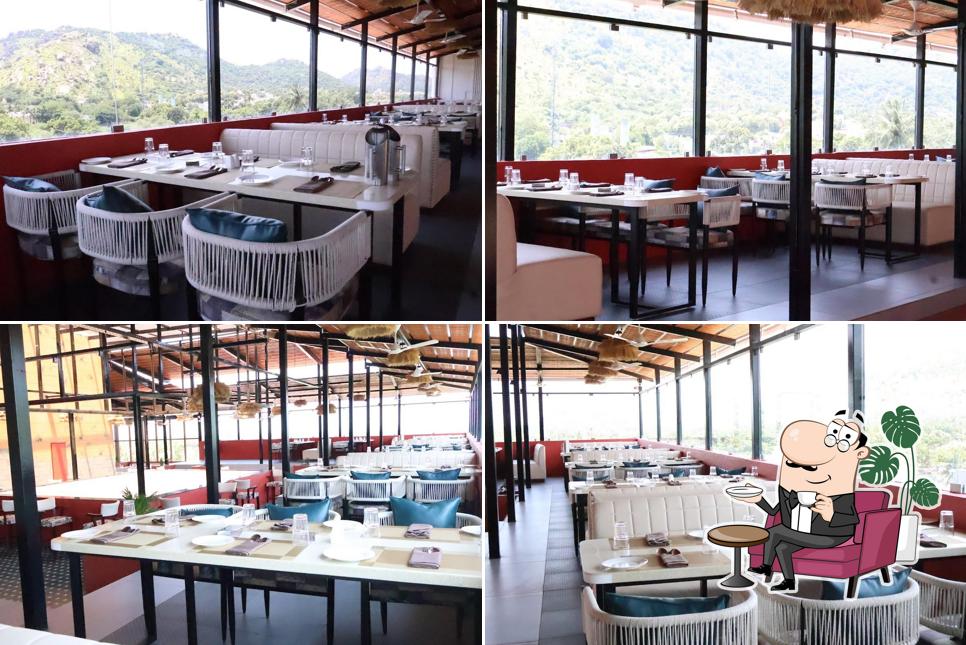 Take a seat at one of the tables at PNS NAKSHATRA - CLOUD NINE - ROOF TOP - MULTICUISINE RESTAURANT