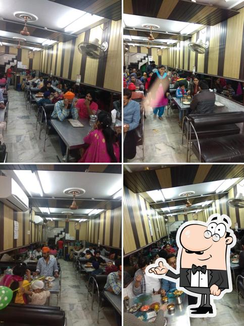 Take a seat at one of the tables at Sanjha Chulha Amritsari Kulcha Specialist