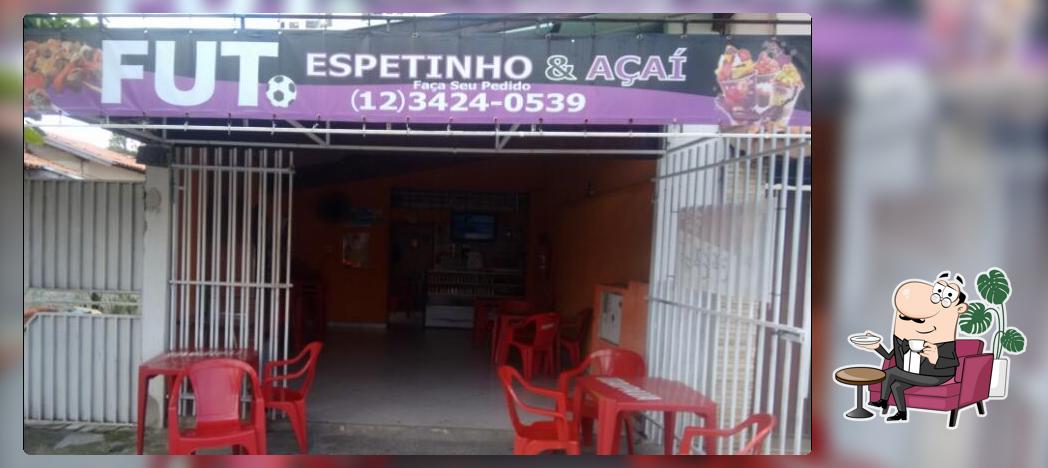 Sente em uma das mesas no Bar Fut Espeto & Açaí