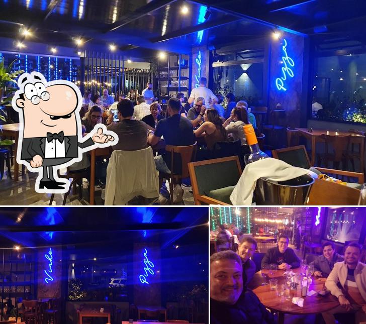 Sente em uma das mesas no Bodega Pizza Entre Vinhos