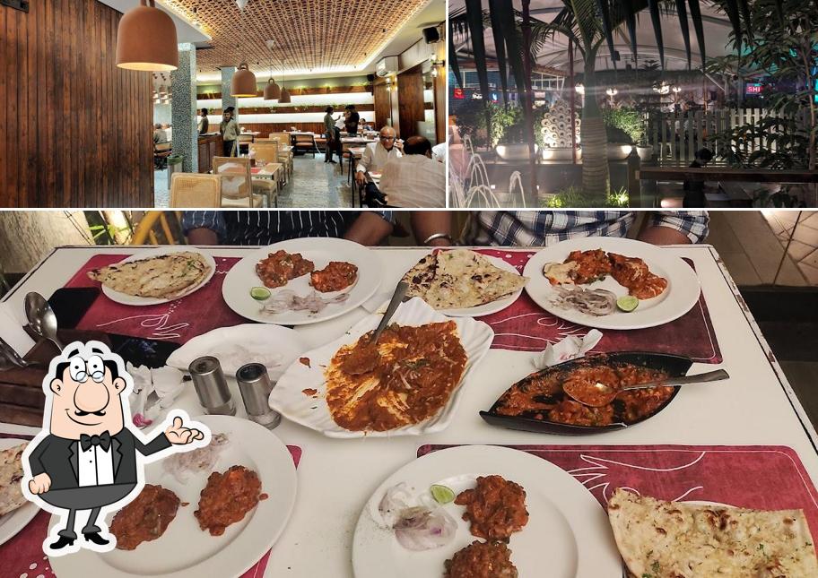 Take a seat at one of the tables at Hotel Mudra - Sprinkle of Love by Bawarchi Restaurant and bar(Nigdi)