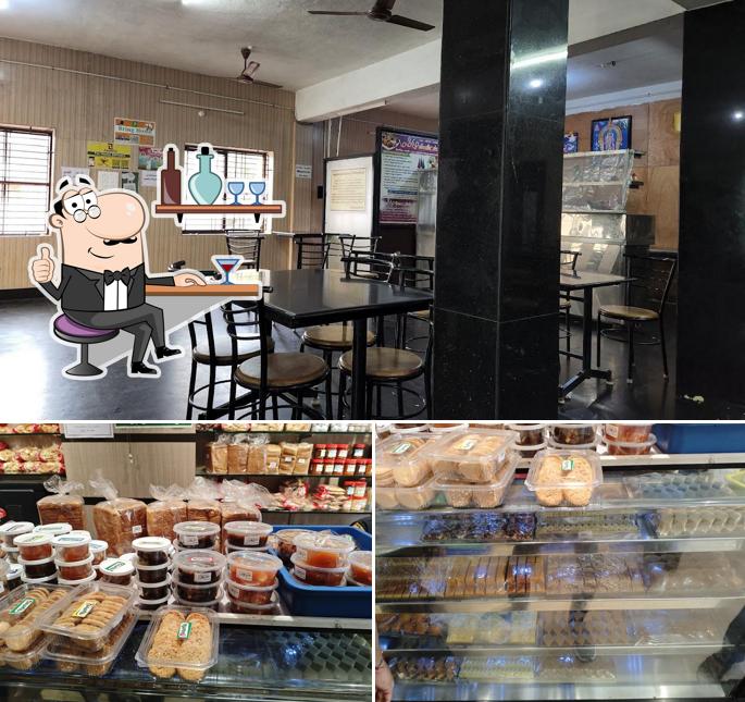 Take a seat at one of the tables at Mammu Sweets Snacks Bakery and Pure Veg Restaurant A/C